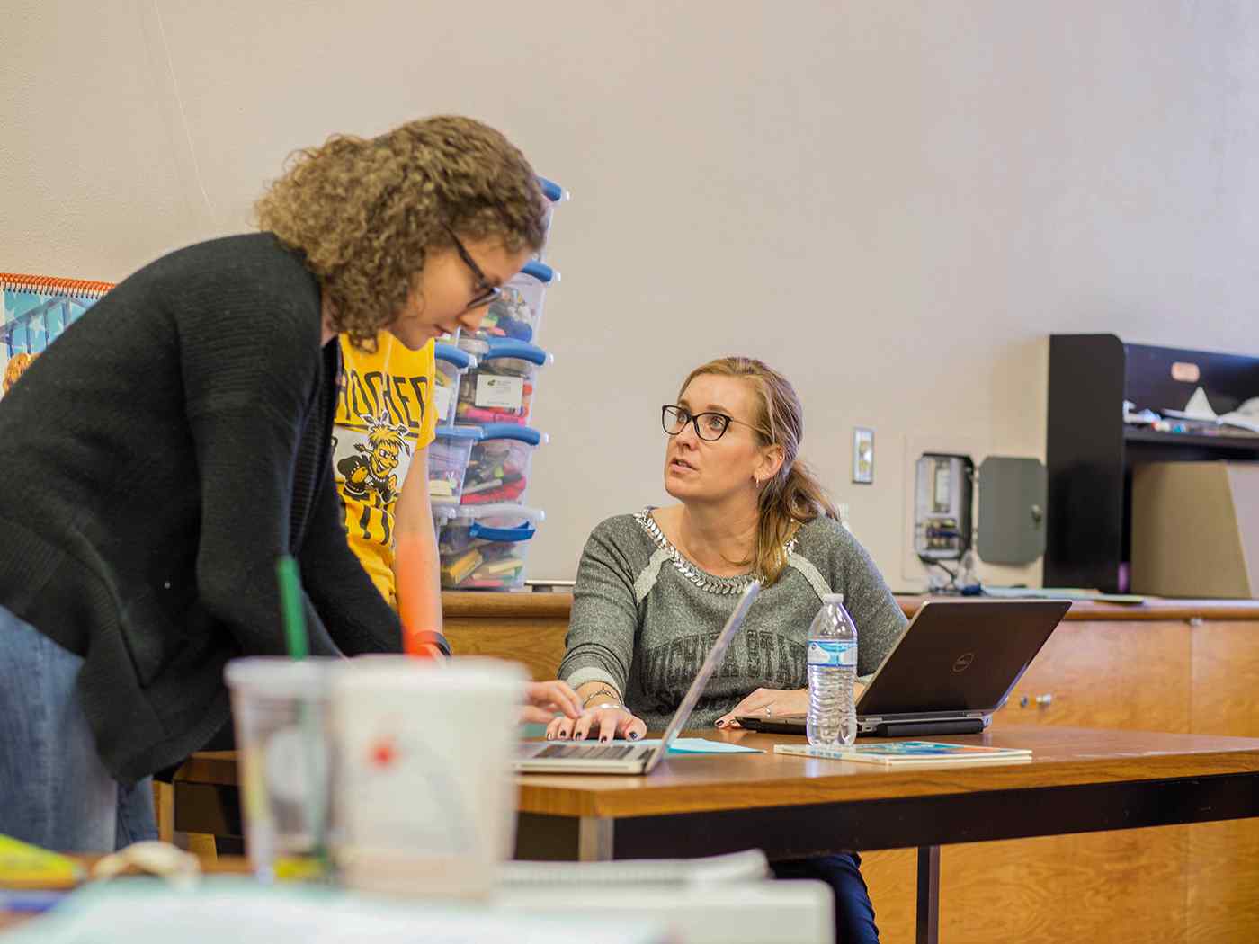 Three Linguistics students studying information on a laptop computer. 