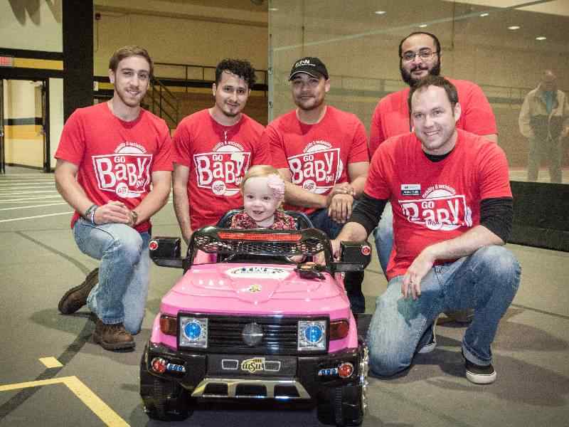 Mechanical Engineering students pose by electric car for Go Baby Go.