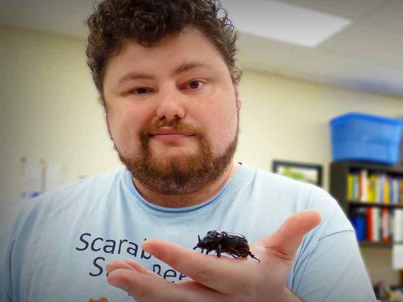 Graduate student holds beetle