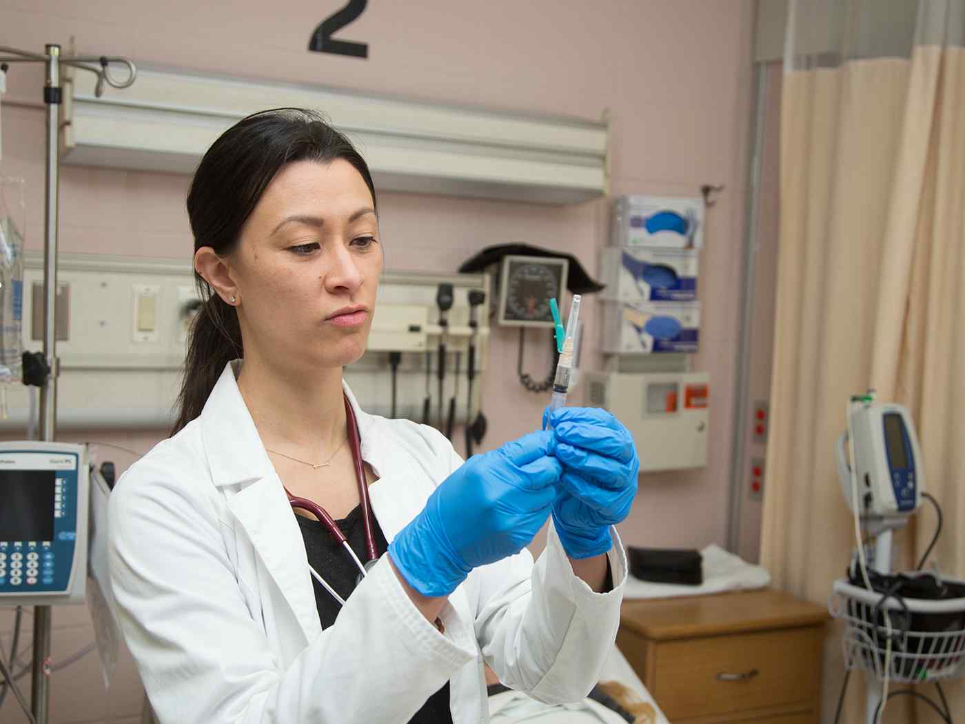 A nursing student preps a syringe