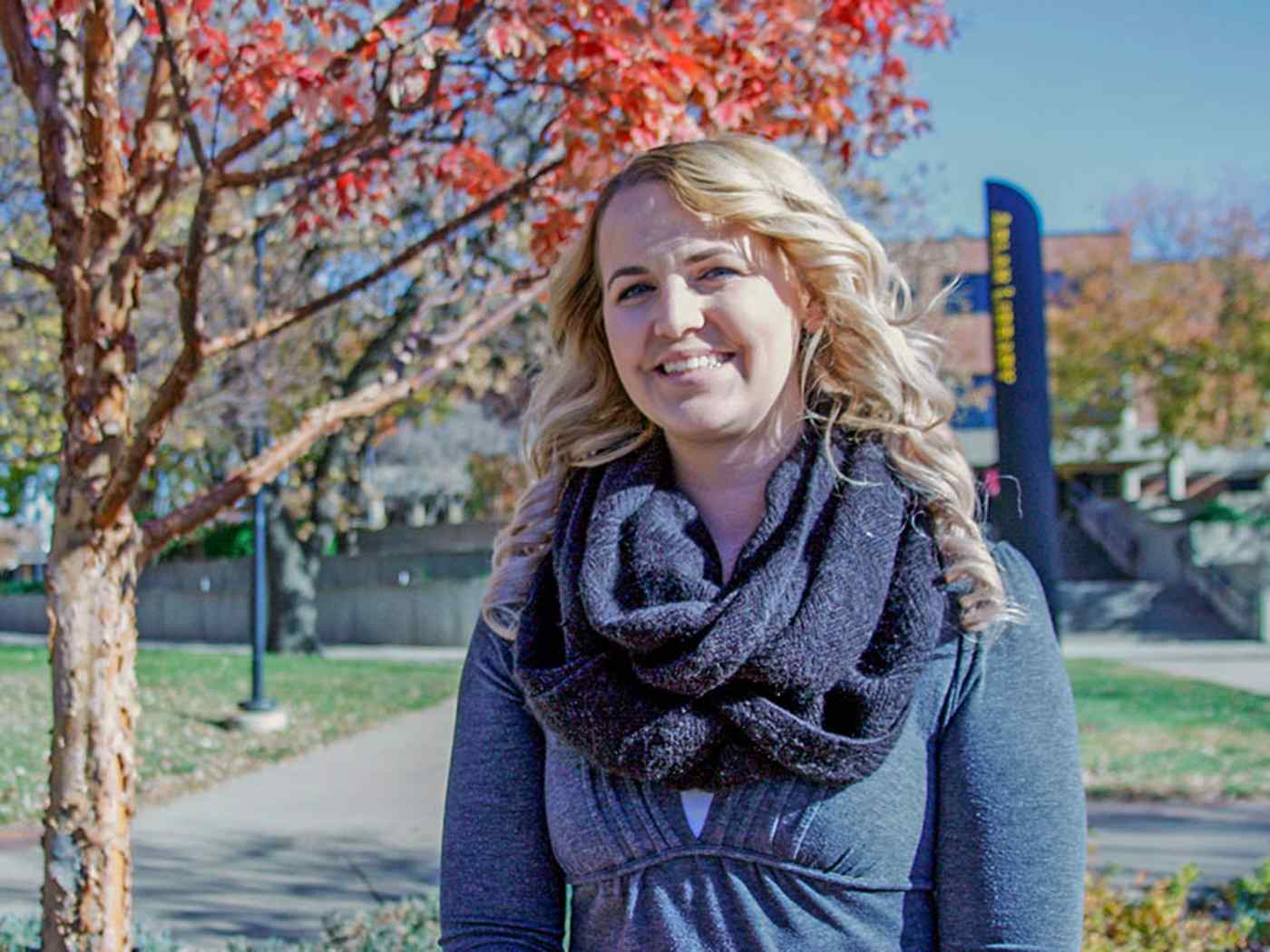 Female psychology student photographed smiling during the day on campus. 