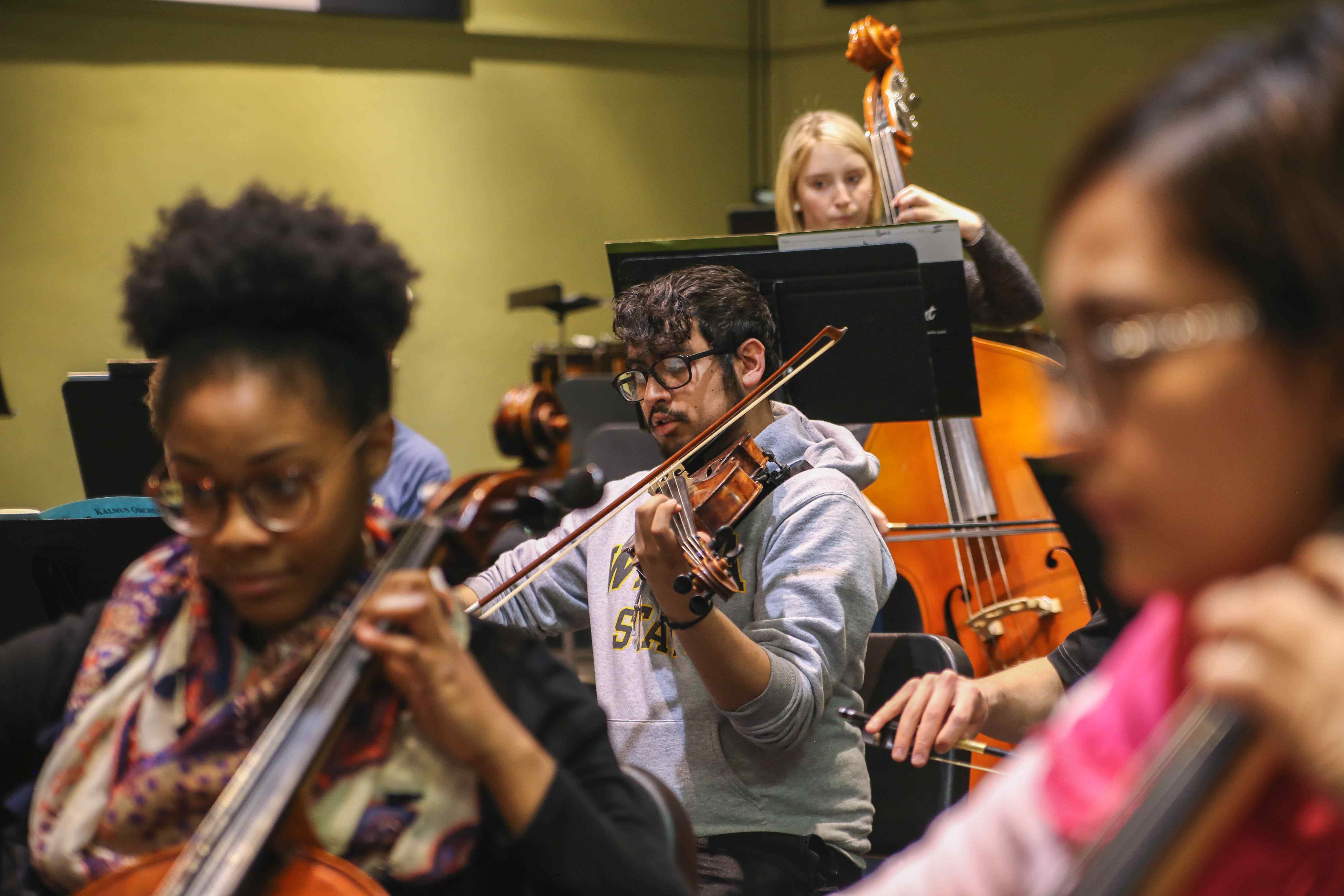 Students using their string instruments.