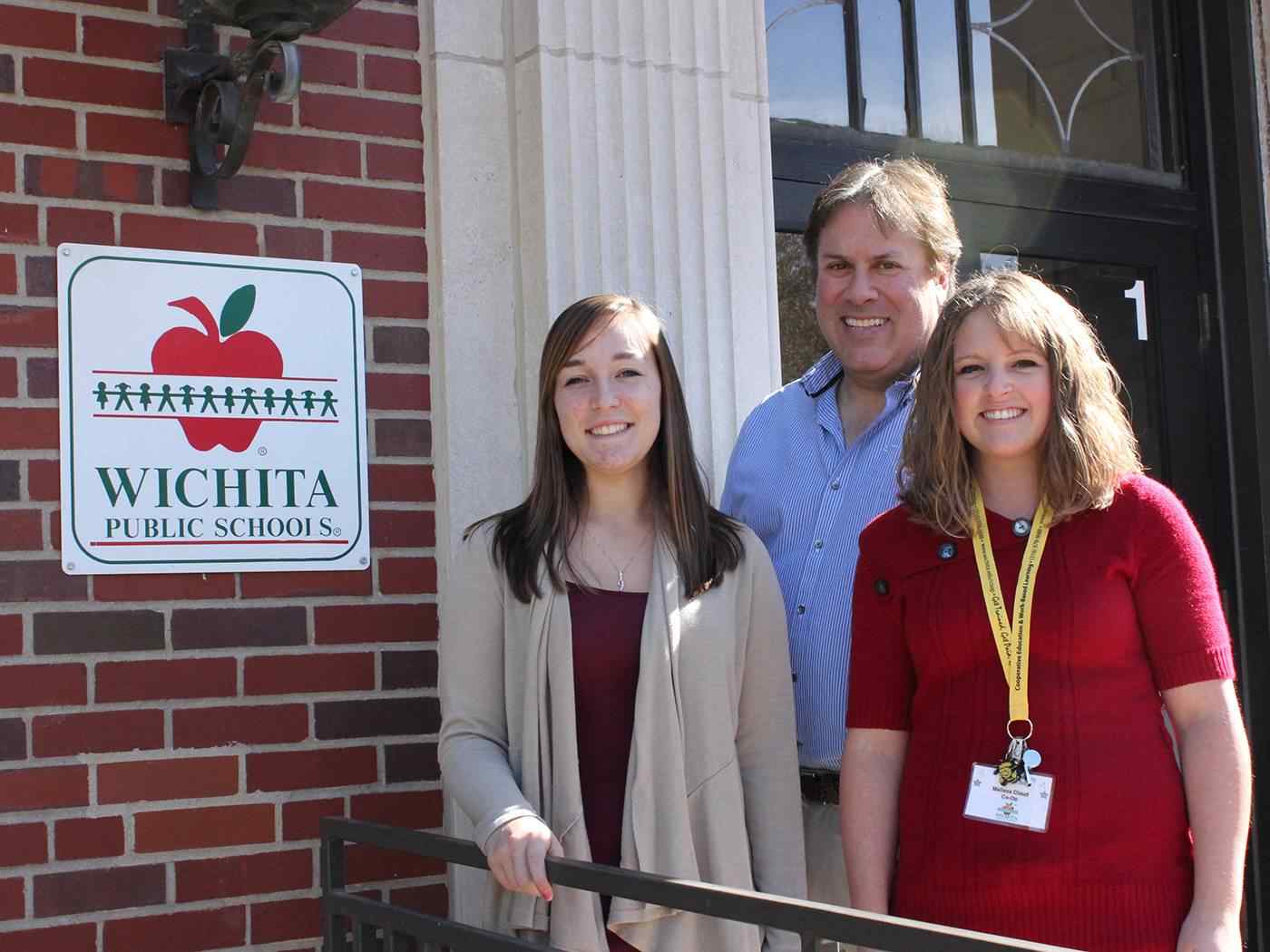 Student teachers posing in front of Wichita Public School building.