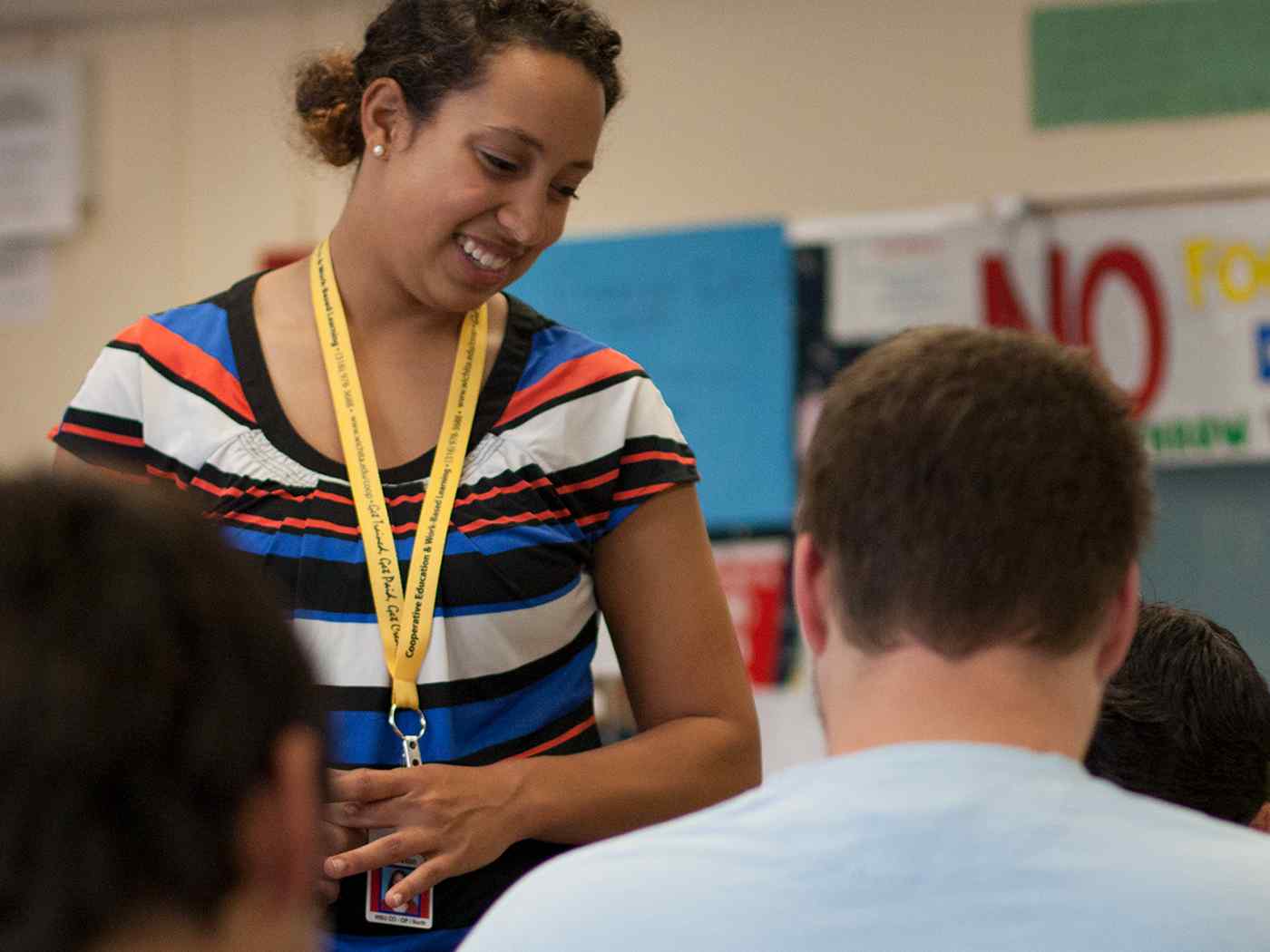 Female student teacher smiling in classroom.