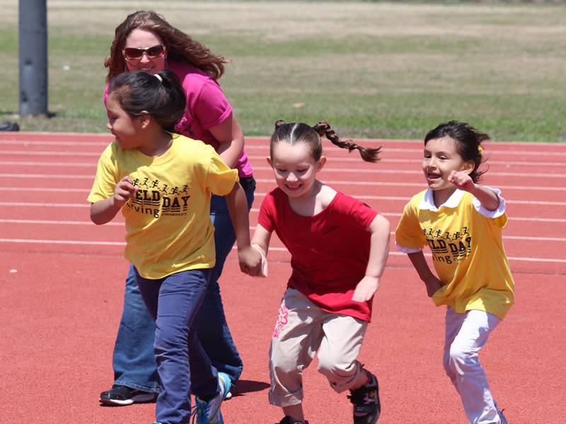 Student teacher running with elementary class.