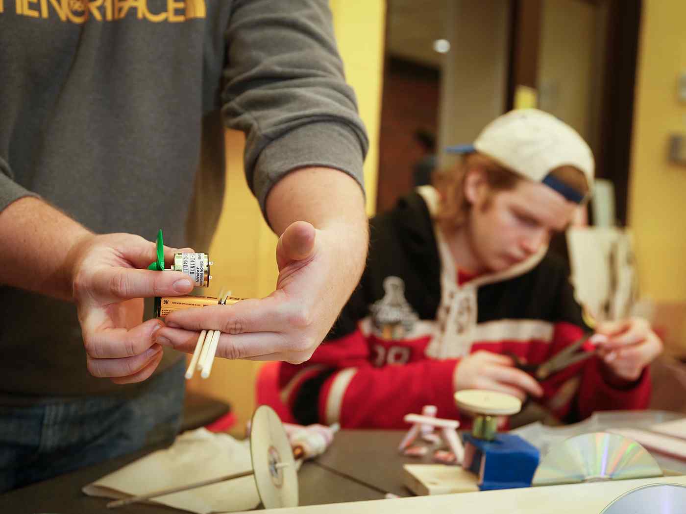 Electrical engineering students measuring various items. 