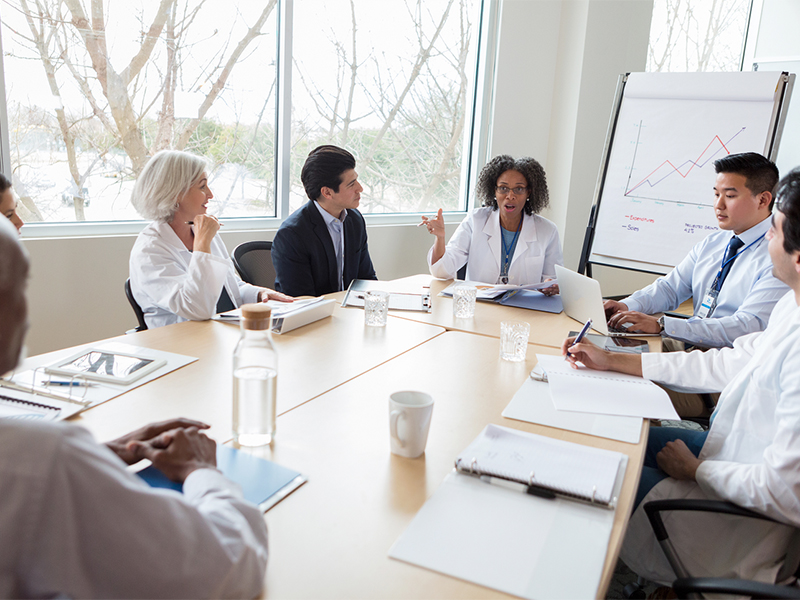 A group of health care professionals meets in a conference room