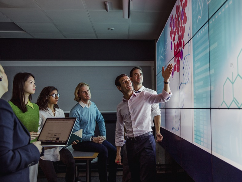 A group of health care professionals examines a data visualization