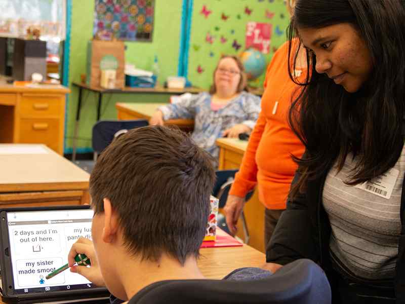 Meghana Ravi assists Katlyn with selecting speech options.