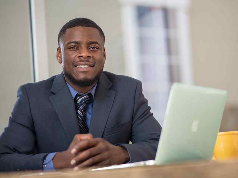 Male graduate student in front of laptop.