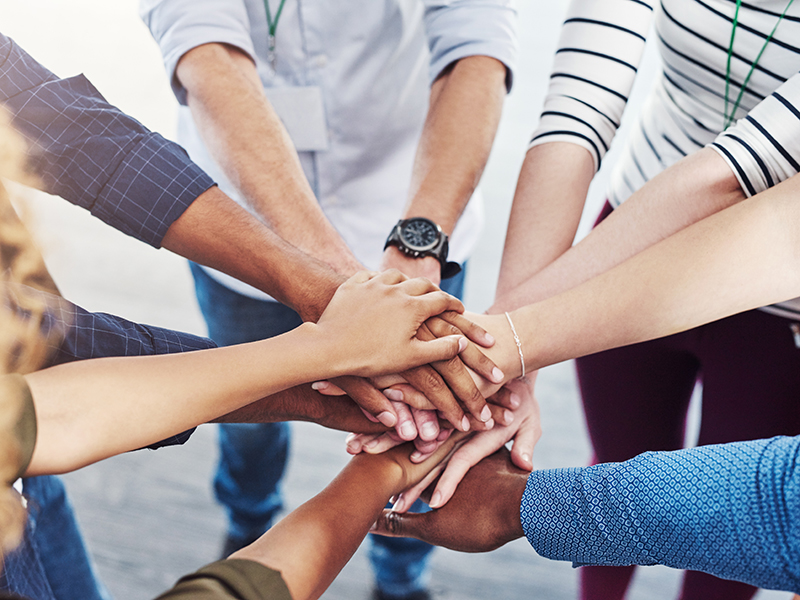 Hands stacked together in a huddle