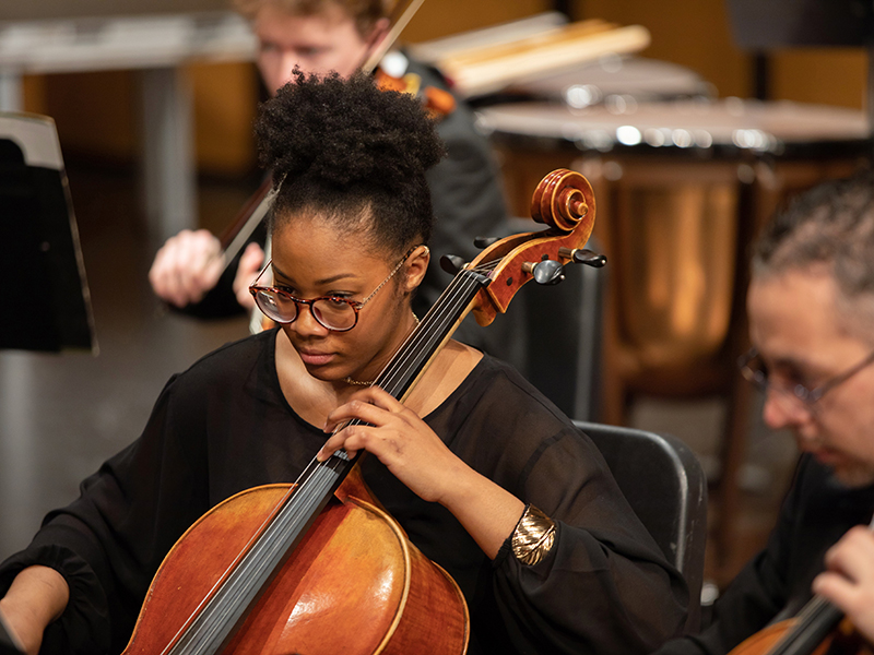 Student playing cello in an ensemble