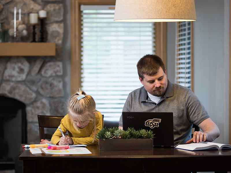 A parent works at home alongside their child