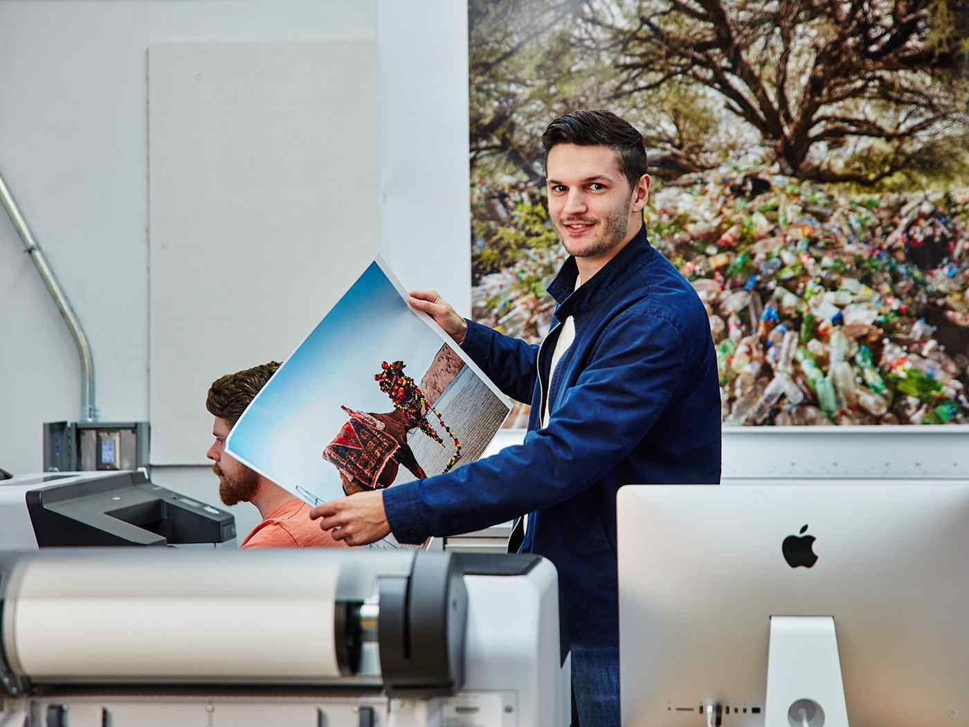 Communications student looking over a large printed photo. 