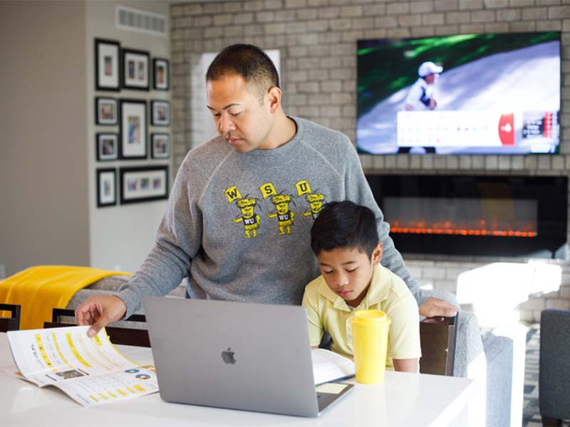 Student on laptop with his son