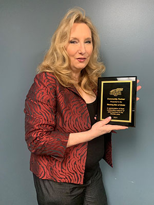 Image of Christie from Working Men of Christ Ministries holding award. 