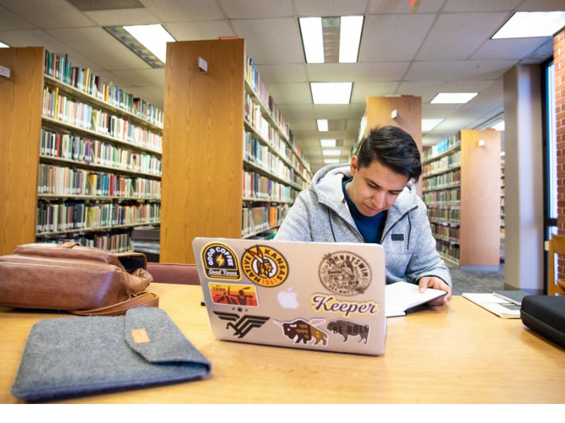 student sitting at a table with laptop open at Ablah Library