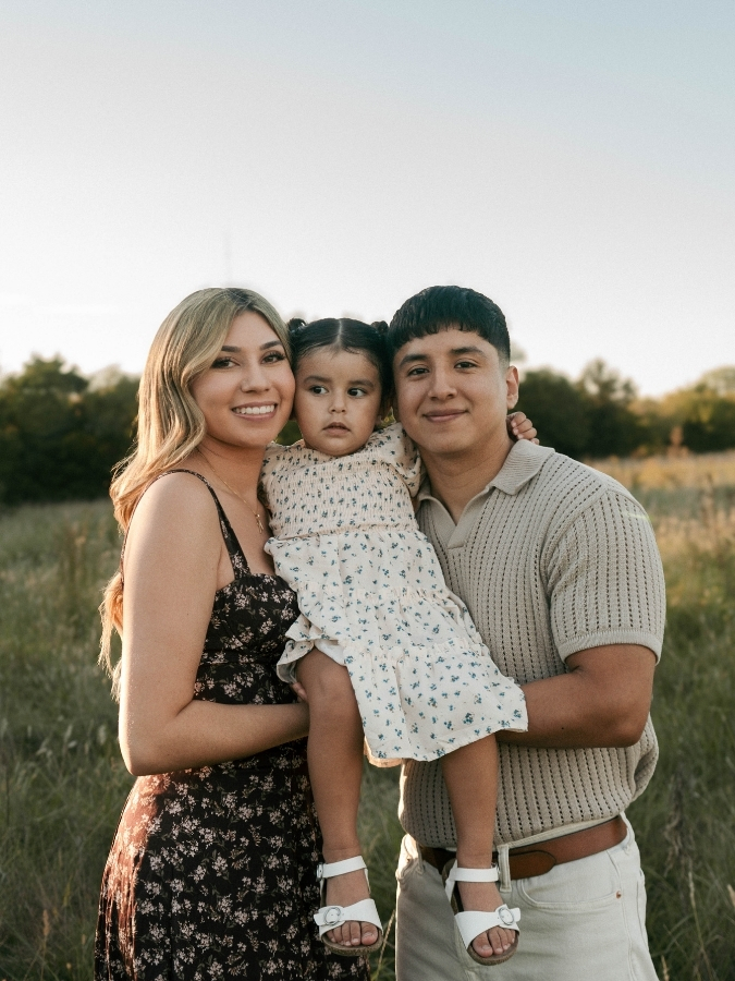 Alicia is pictured hugging her child and significant other.