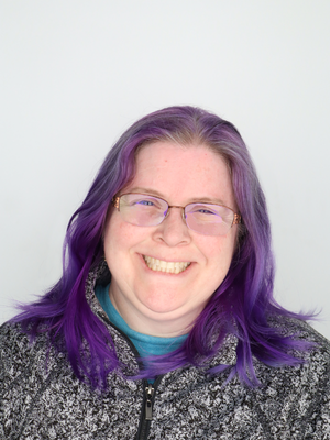 A smiling student with purple hair