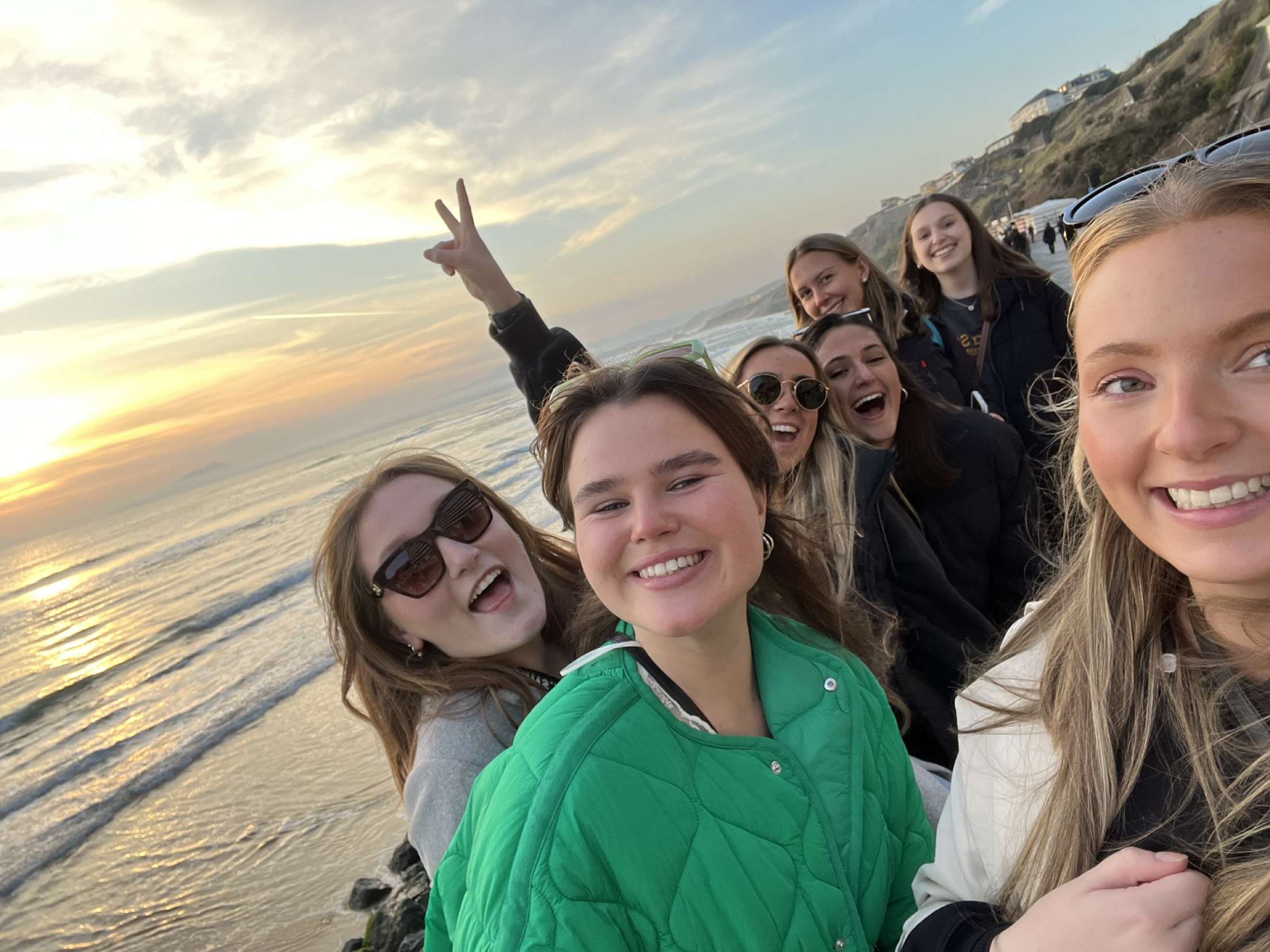 Students taking selfie by ocean