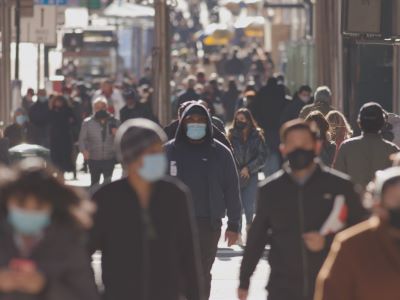 Crowded street with people wearing masks
