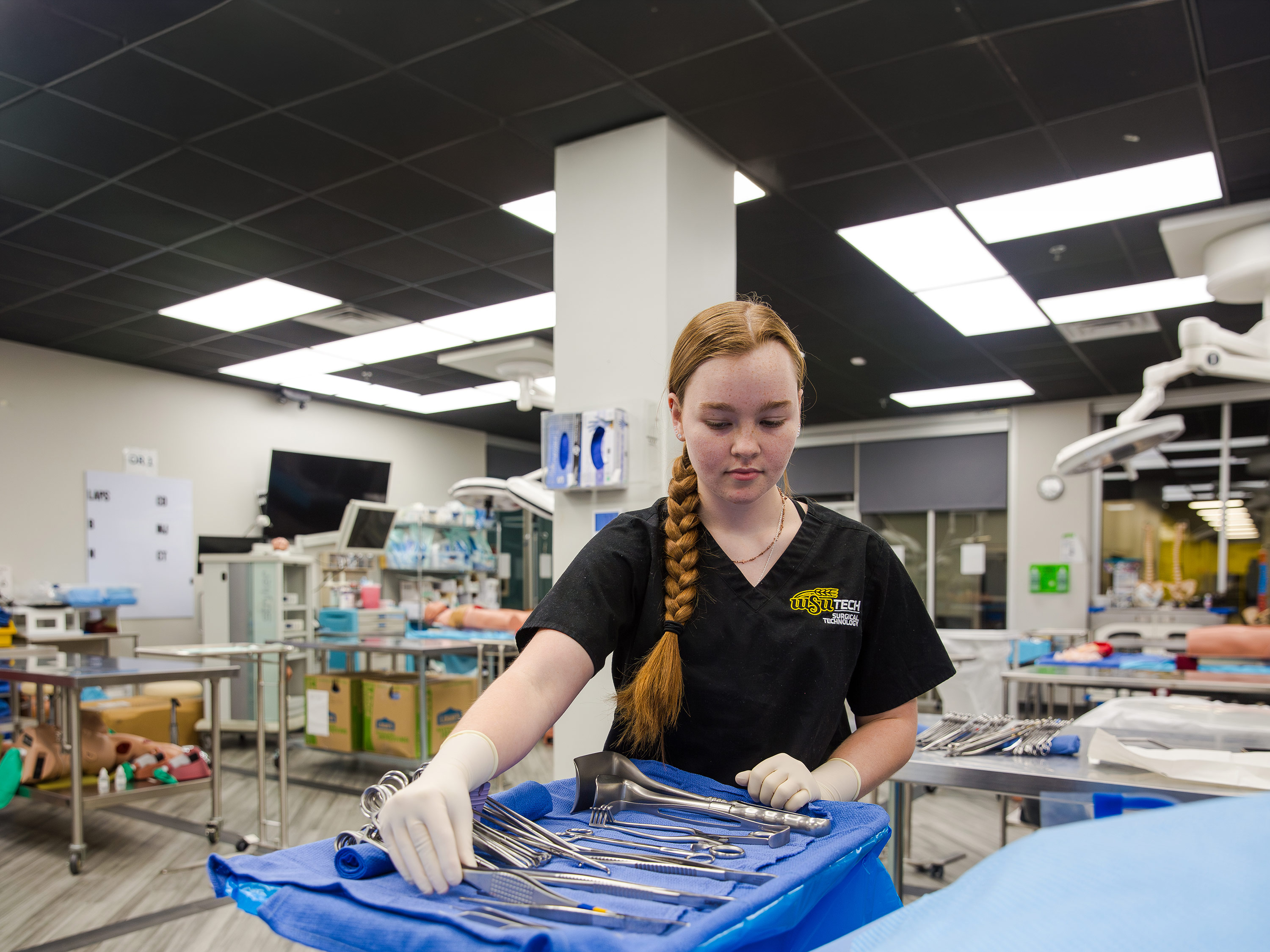 WSU Tech surgical technology student organizing a tray of medical instruments.