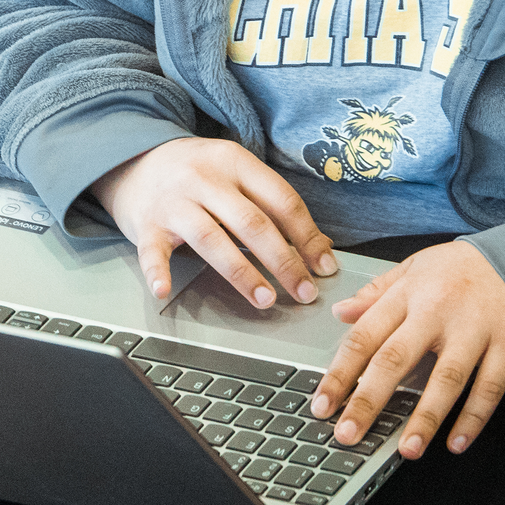 Close-up of someone typing at a laptop keyboard