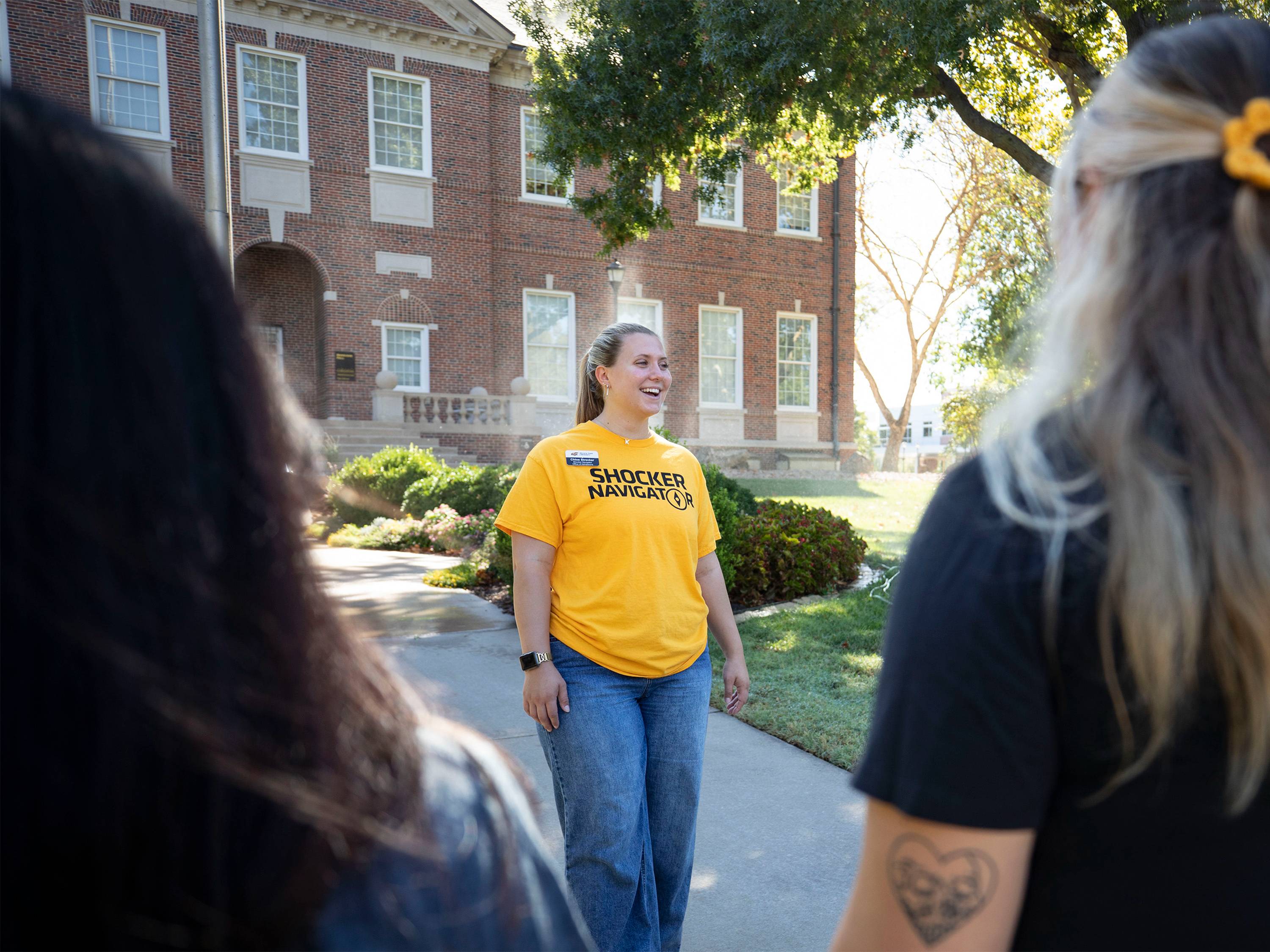 Shocker Navigator guide in front of Morrison Hall leading a tour of campus.