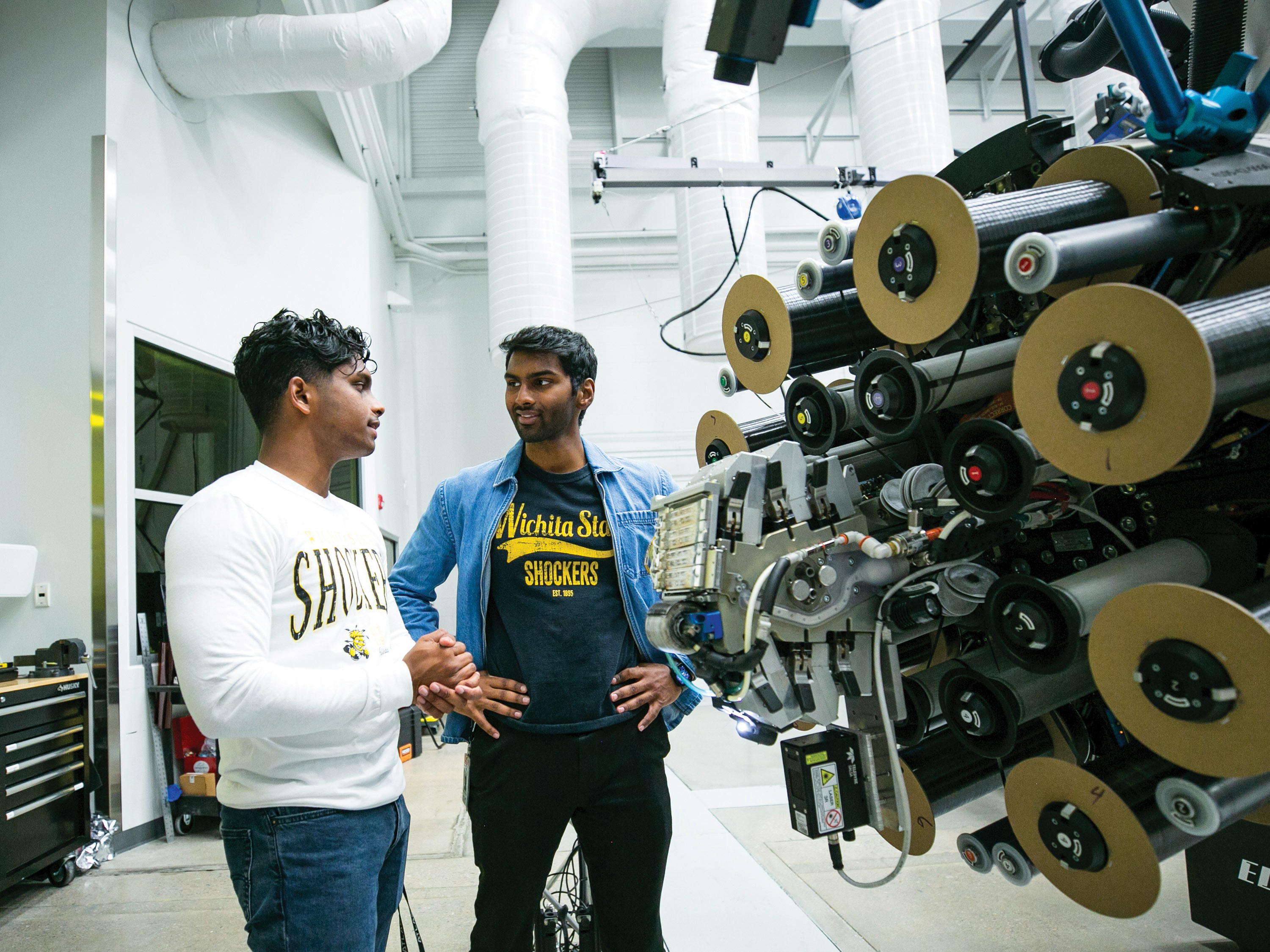 Two students pause for discussion in an engineering lab.
