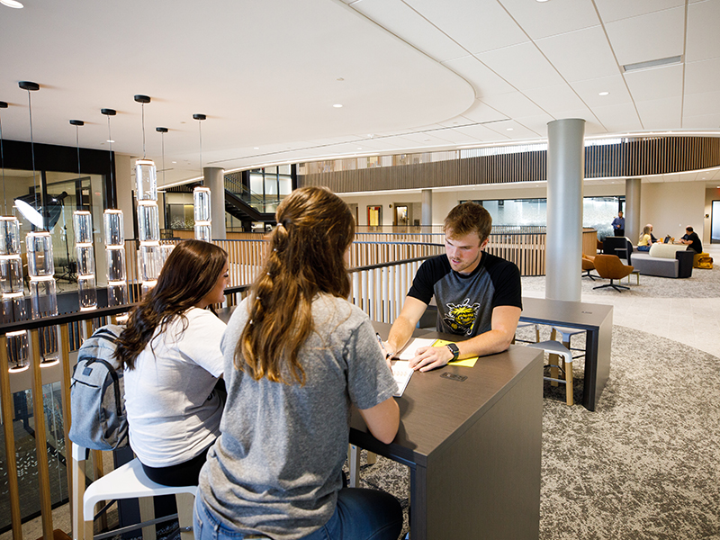 Three students study at a table in Woolsey Hall.