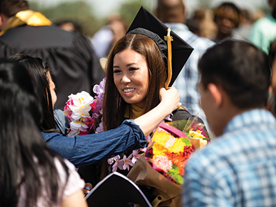 A student at graduation with their family