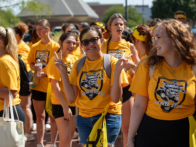A student poses making peace signs with their hands at Clash of the Colleges