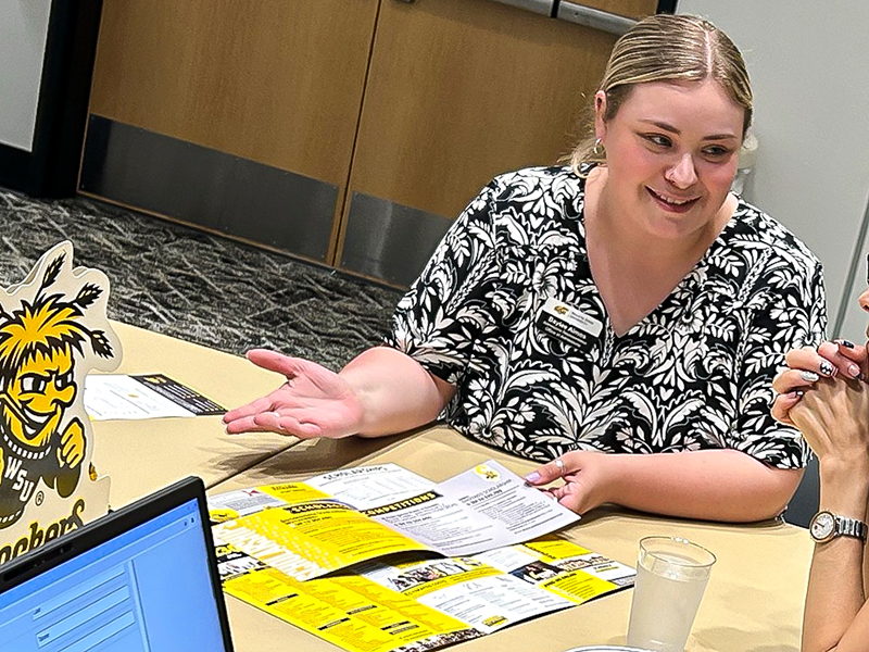 Baylee Almos, admissions representative, helps a prospective student.