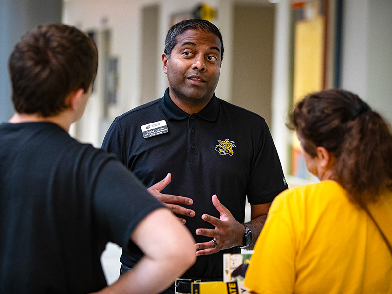 Bobby Gandu, Associate VP for Strategic Enrollment Management, Applied Learning & Director of Undergraduate Admissions, talks with a student and parent at Wichita State Activate: An Application Kick-Off Event.