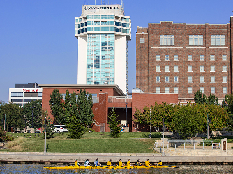 Students rowing on the Arkansas River near downtown Wichita. Boats & Bikes offers rowing rentals and lessons.