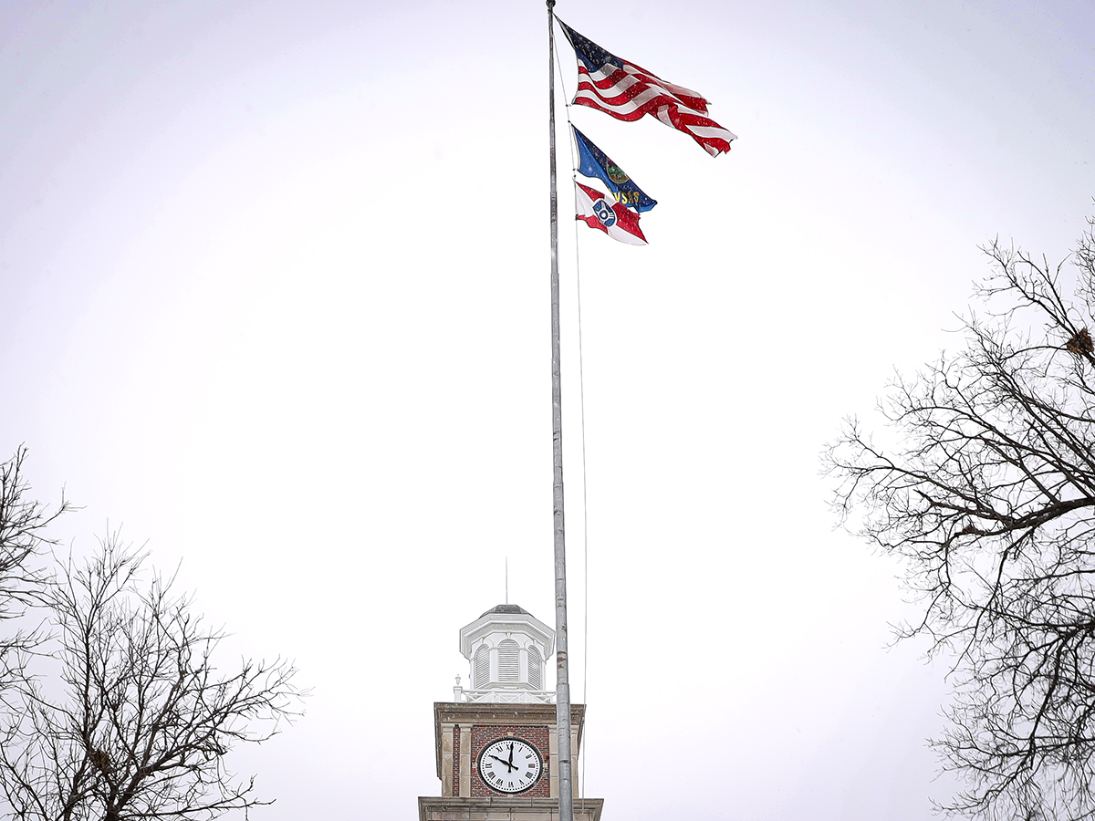 The Wichita flag (bottom) flies beneath the American and Kansas flag outside of Morrison Hall on Wichita State's campus during the winter.