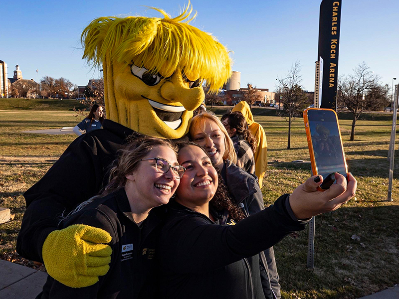 Wichita State's Kaylan Richardson, Tais Solis and Riley McMillan pose for a photo with Wu.