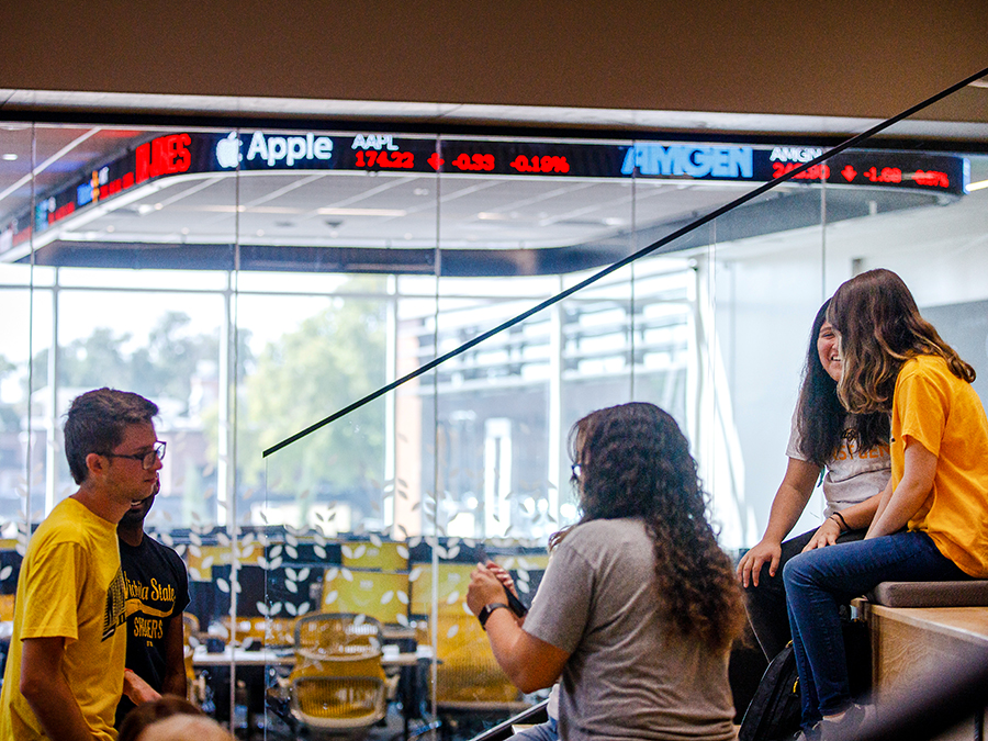 Students chatting outside of the Koch Global Trading Center at the Barton School of Business.