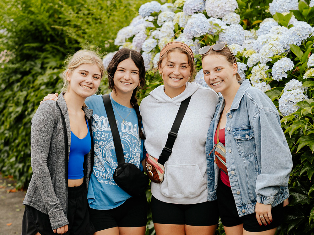 Sophie Walter, left, and members of her study abroad group pose for a photo in front of hydrangeas in Pau, France.