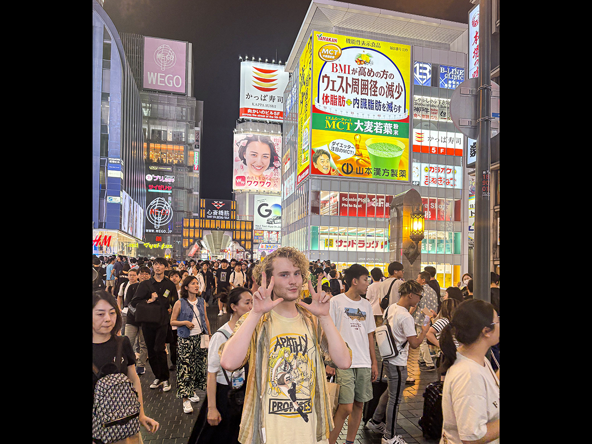 Owen Klos posing for a photo on Dotonbori Street in Osaka, Japan.