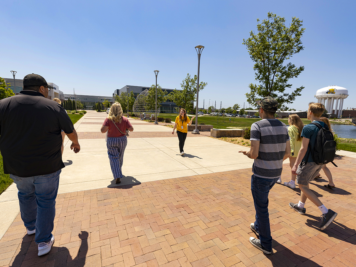 Campus visitors walking through campus on a sunny day.