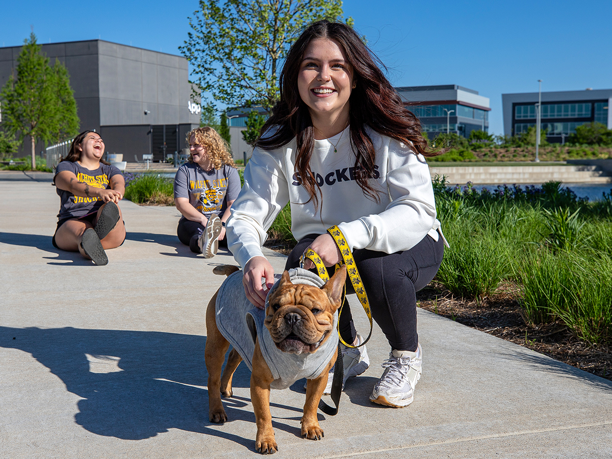 Student with a dog on campus.