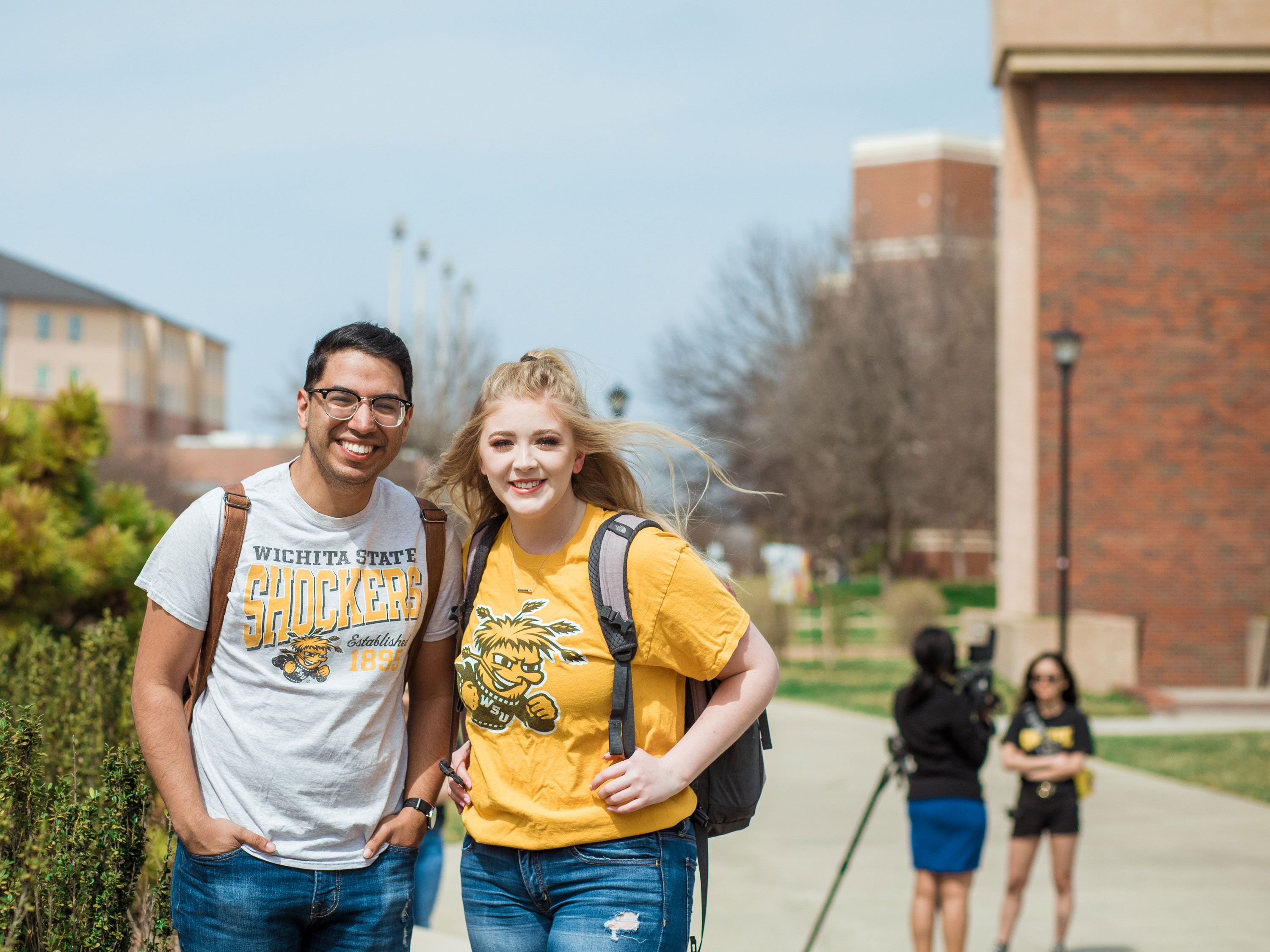 Two students with backpacks standing in from of the Rhatigan Student Center.