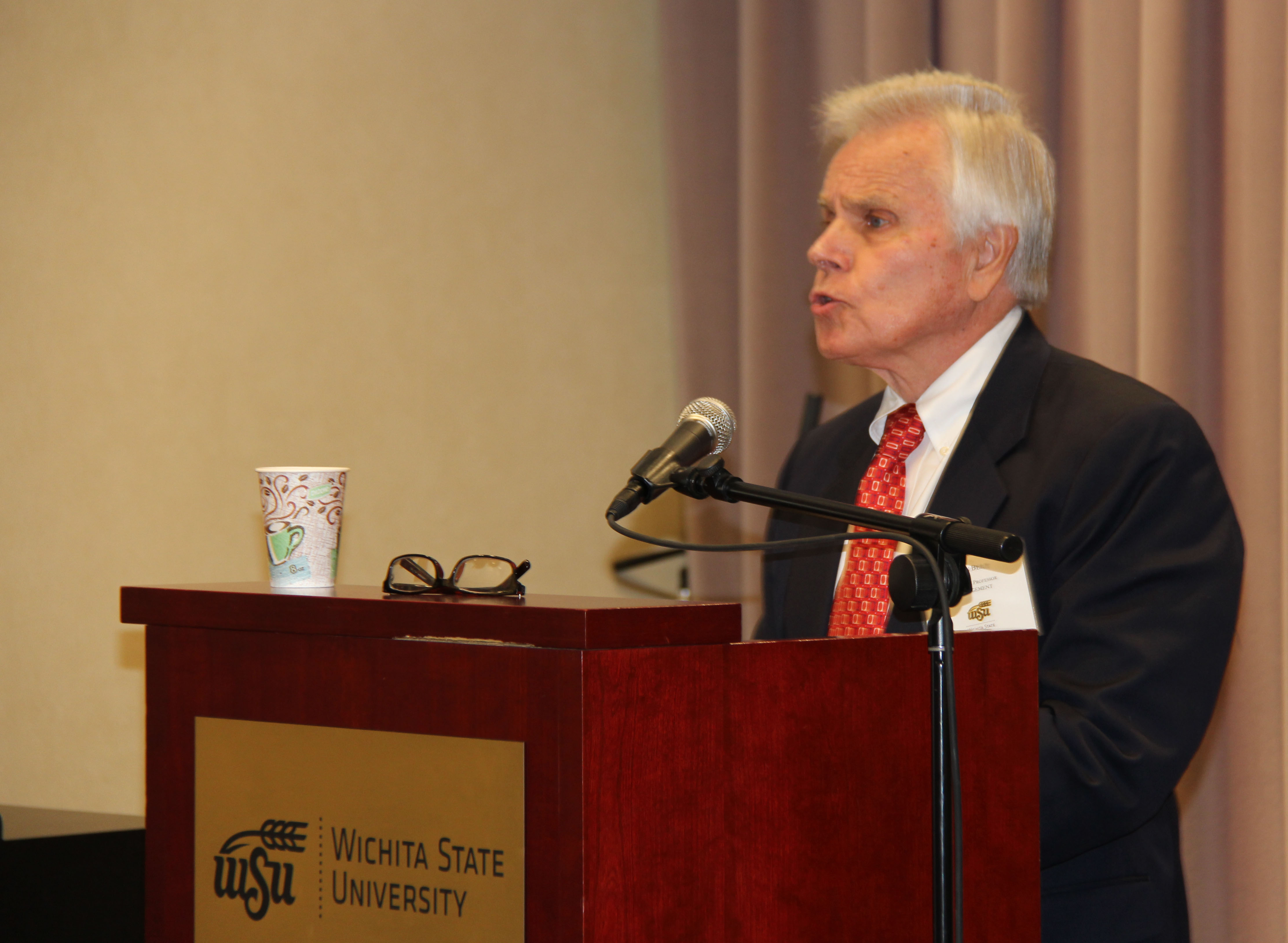 Photo of AET President John Belt addressing reception attendees.