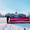 Luz Aguirre posing in the snow with the Bridgewater State University sign. Aguirre studied at Bridgewater State University through National Student Exchange. 