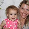 A woman smiles with a toddler.