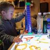 A child interacts with alphabet letters on a light box.