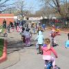 A large group of children bicycles on the street.