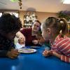 A staff member pours water onto a plate of Skittles to show how the colors react.