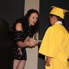 A child graduates the Child Development Center in a yellow cap and gown.